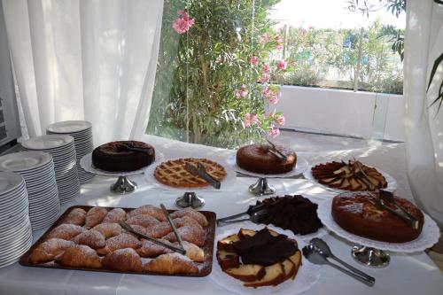 ヴィエステにあるHotel Gabbiano Beachのケーキとペストリーを上に置いたテーブル