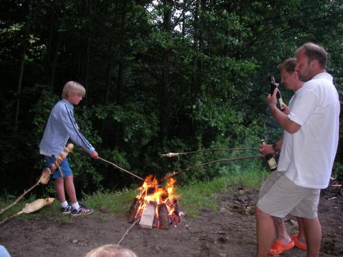 a man and a boy are standing around a fire at Turnerhof in Millstatt