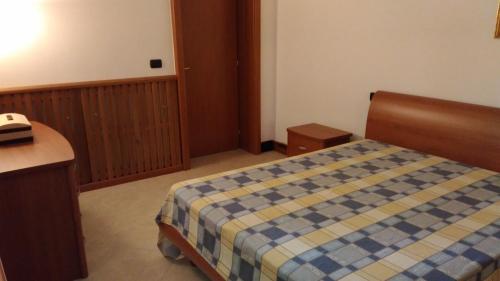 a bedroom with a bed with a blue and yellow blanket at La Pietra Smeraldina in Santo Spirito