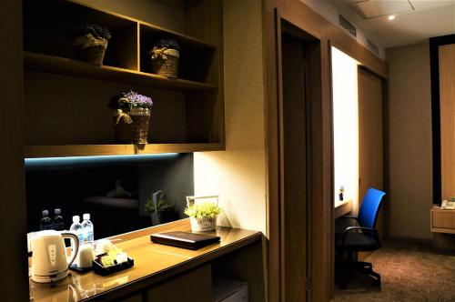 a office with a desk and a chair and a room at Greens Hotel & Suites in Bintulu