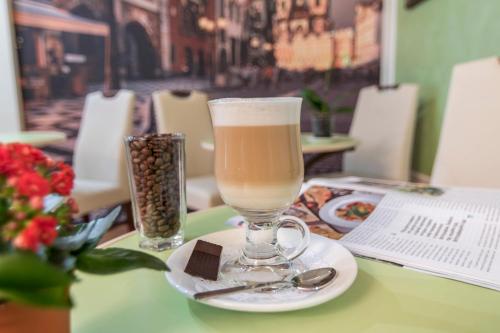 un vaso de cerveza sentado en una mesa con un plato en Centralny Hotel, en Krivoy Rog