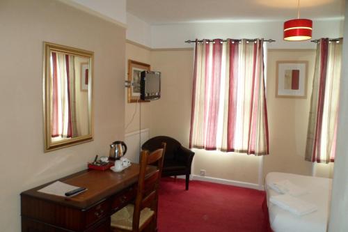 um quarto com uma secretária e uma cadeira num quarto em Severn View Hotel em Worcester