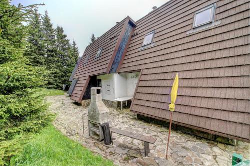 a house with a flag and a bench next to it at Apartma David Rogla in Zreče