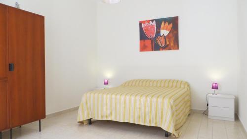 una camera da letto con un letto e un dipinto sul muro di Centralissimo Perla Nera a Gallipoli