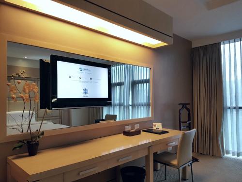 a room with a desk with a television on a mirror at Cebu Parklane International Hotel in Cebu City