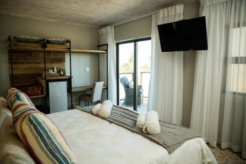 a bedroom with a bed with a television on the wall at Driftwood Guesthouse in Swakopmund