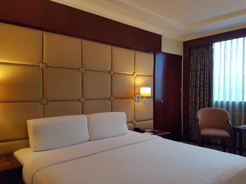 a bedroom with a large white bed and a window at Cebu Parklane International Hotel in Cebu City