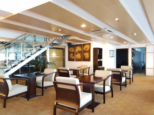 a dining room with tables and chairs and stairs at Cebu Parklane International Hotel in Cebu City