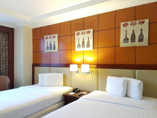 two beds in a hotel room with two lamps at Cebu Parklane International Hotel in Cebu City