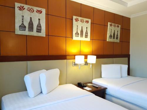 a hotel room with two beds and two lamps at Cebu Parklane International Hotel in Cebu City