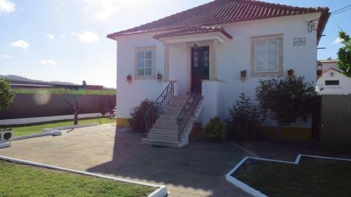 a white house with a staircase in a yard at Vivenda Maria de Lourdes in Maiorga