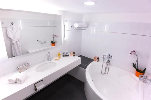 Baño blanco con 2 lavabos y espejo en The Seasons Hotel -Studio & Suite en Netanya