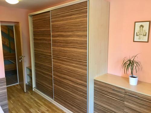 a large wooden closet in a room with pink walls at Penzion 103 in Železná Ruda