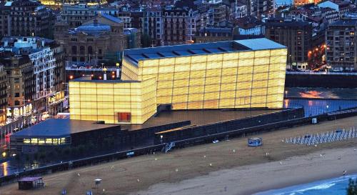 a large yellow building in a city at night at HOTEL ARRiZUL BEACH in Donostia-San Sebastián