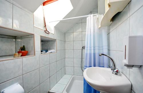 a white bathroom with a sink and a shower at Studio apartment Ante in Zadar