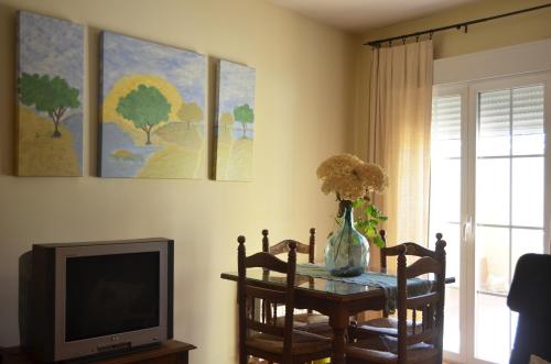 sala de estar con mesa y TV en Hostal Refugio De Gredos, en Navarredonda de Gredos