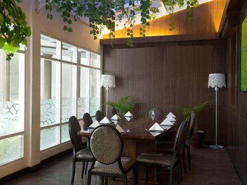 a dining room with a table and chairs and windows at BW Kemayoran Hotel & Convention Powered by Archipelago in Jakarta