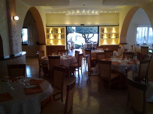 a dining room with tables and chairs in a restaurant at Hotel La Campagnola in Capo Vaticano