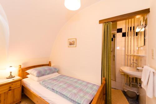 a small bedroom with a bed and a sink at Gasthof Grillitsch Rösslwirt in Obdach