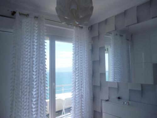 ein Bad mit einem Fenster mit Meerblick in der Unterkunft Beautifull Holiday Apartment Larisa in Sarandë