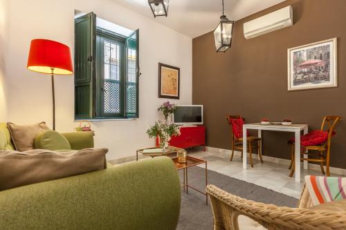 sala de estar con sofá y mesa en Apartamentos Mariscal, en Sevilla