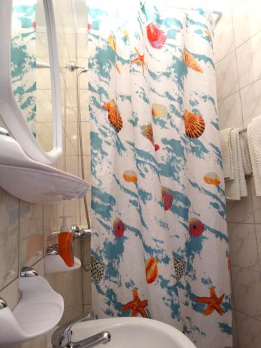 a bathroom with a shower curtain with fish on it at Pansion Belveder in Crikvenica