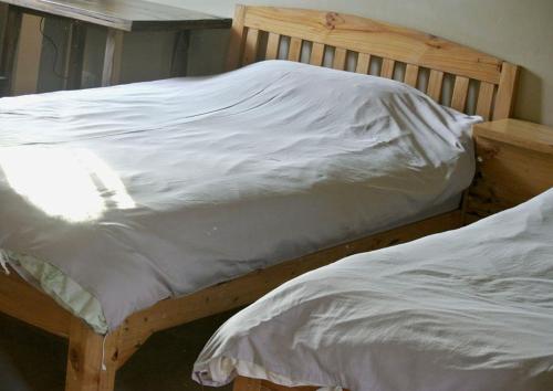 two twin beds in a bedroom with white sheets at Jamjuree Garden in Ban Thung Ma Nieo