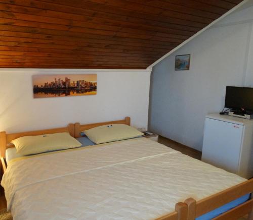 a bedroom with a bed and a television in it at Pansion Belveder in Crikvenica