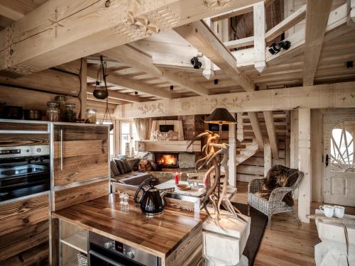 sala de estar con paredes de madera y chimenea en GORSKA OSADA Lovely Chalets Zakopane, en Poronin
