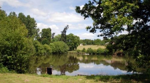 a body of water with trees and a river at Yourte d'Aiguevives in Céré-la-Ronde