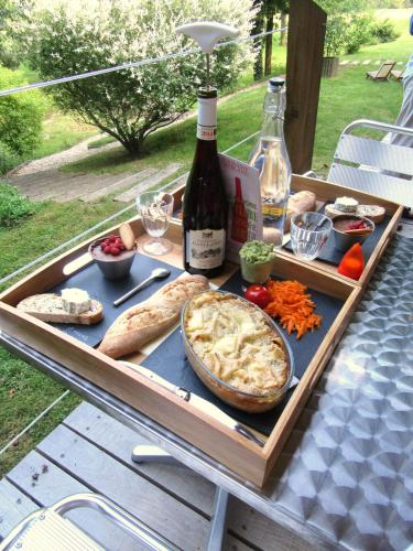 - une table avec un plateau de nourriture et une bouteille de vin dans l'établissement D'une Autre Nature, à Mesland