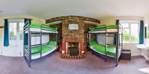 two bunk beds in a room with a fireplace at YHA Land's End - Cot Valley in St. Just