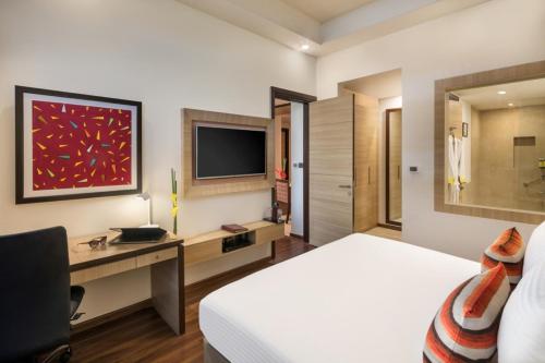 Una televisión o centro de entretenimiento en Sandal Suites by Lemon Tree Hotels