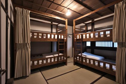 una stanza con tre letti a castello di Kanazawa Guest House East Mountain a Kanazawa
