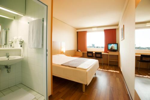 a hotel room with a bed and a bathroom at Ibis Wien Mariahilf in Vienna