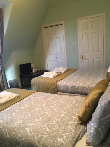 a bedroom with two beds and a desk with a computer at Airdenair Guest House in Edinburgh