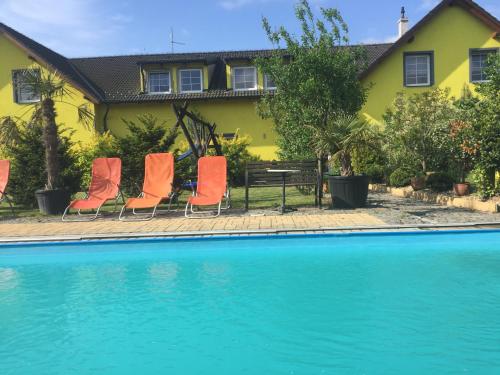 a house with orange chairs next to a swimming pool at Ubytování U draka in Třeboň