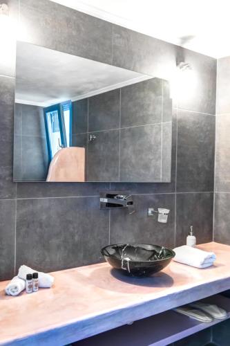 a bathroom with a sink and a mirror at Desiterra Resort & Spa in Fira