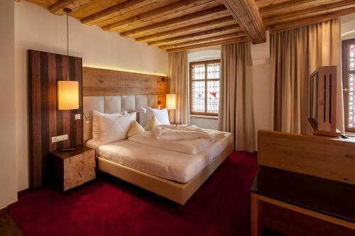 a bedroom with a bed and a television in it at BEST WESTERN Plus Hotel Goldener Adler Innsbruck in Innsbruck