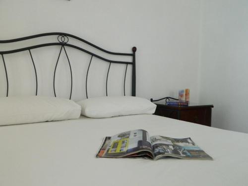 a magazine sitting on top of a bed at Ioanna Apartments in Agios Prokopios