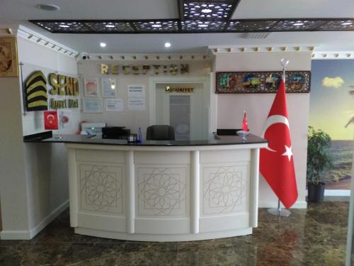 a reception counter in a building with a red flag at Send Apart Otel in Antalya