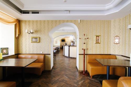 a restaurant with wooden tables and chairs and a corridor at Hotel Irena in Lviv