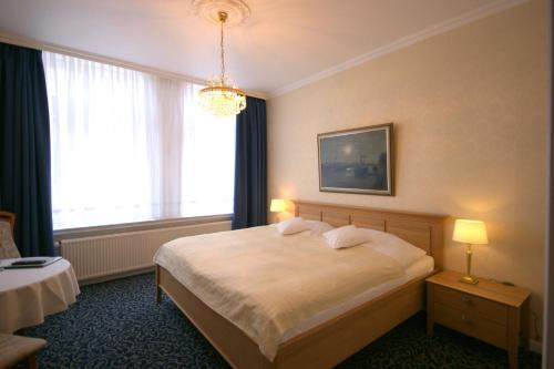 a hotel room with a bed and a window at Hotel Beckröge in Cuxhaven