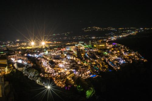 a city lit up at night with lights at Anteliz Suites in Fira