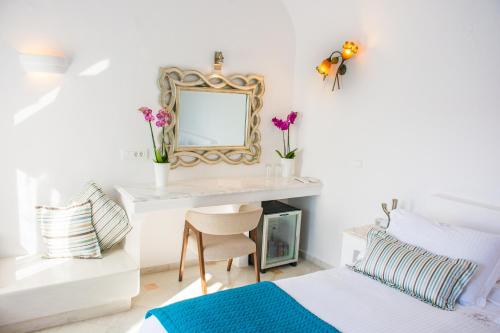 a bedroom with a desk with a mirror and a bed at Anteliz Suites in Fira