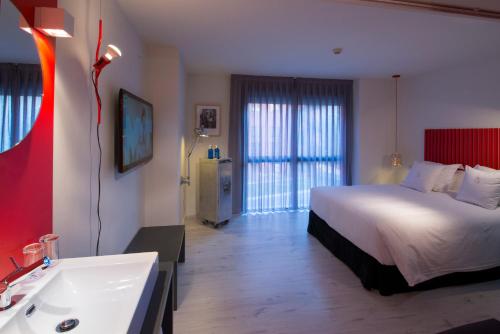 a bedroom with a bed and a sink and a tub at Hotel Mirador de Chamartín in Madrid