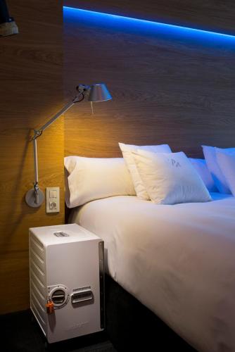 a bedroom with a large white bed with a blue light at Hotel Mirador de Chamartín in Madrid