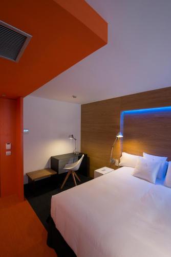 a bedroom with a large white bed and a desk at Hotel Mirador de Chamartín in Madrid