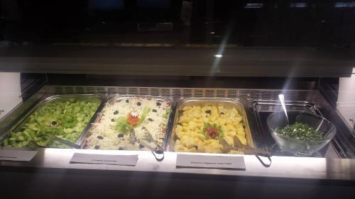 een vitrine met dienbladen van verschillende soorten levensmiddelen bij Balneo & SPA Hotel Aura in Velingrad