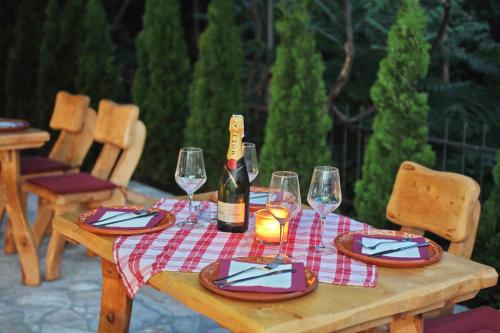 a wooden table with glasses and a bottle of wine at Apartments Amigo in Kotor